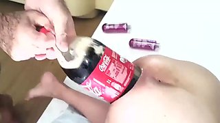 Putting a massive and girthy bottle in her asshole