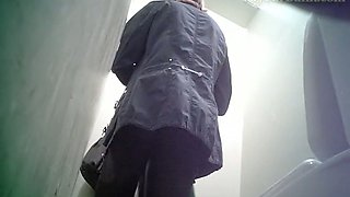 Pale skin blonde lady in the public toilet room recorded on spycam