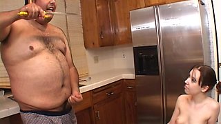 Chubby guy eating while fucking a sexy brunette in his kitchen