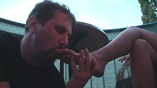 Sexy femdom smoking a cigarette while getting feet licked and toes sucked